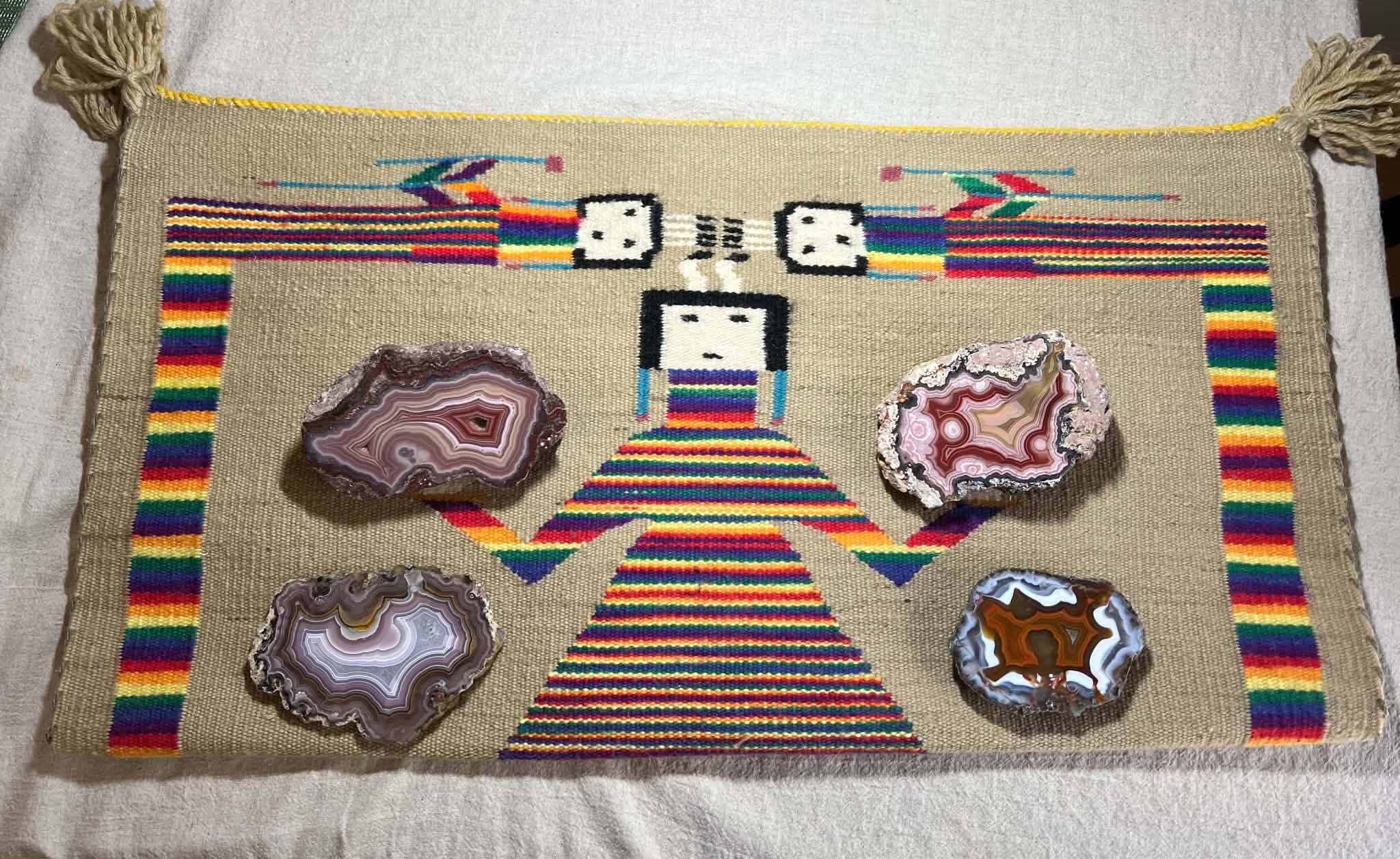 Four banded agates resting on a richly colored woven textile from Gary’s collection